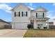 Well-kept two-story home featuring an attached two-car garage and a welcoming front porch with white railings at 615 Ravens Wood Rd, Summerville, SC 29486