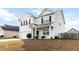 Charming two-story home showcasing a well-manicured lawn and inviting front porch in a neighborhood setting at 615 Ravens Wood Rd, Summerville, SC 29486