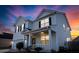 Charming two-story home featuring classic siding, black shutters, and a welcoming front porch at sunset at 615 Ravens Wood Rd, Summerville, SC 29486