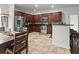Bright eat-in kitchen boasts stainless appliances, beautiful tile floor, and dark wood cabinetry at 615 Ravens Wood Rd, Summerville, SC 29486