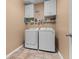 Bright laundry room with washer, dryer, white cabinets, and practical shelving for storage and supplies at 615 Ravens Wood Rd, Summerville, SC 29486