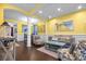 Open living area with dark wood floors, stylish furniture, and bright, yellow walls at 615 Ravens Wood Rd, Summerville, SC 29486