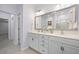 Bright bathroom features a double sink vanity, white cabinets, and large mirror reflecting a glass-enclosed shower at 625 Sienna Way, Summerville, SC 29486