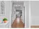 Bright hallway featuring hardwood floors, white walls and trim and a decorative mirror at 625 Sienna Way, Summerville, SC 29486
