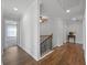 Upstairs hallway featuring hardwood floors, a ceiling fan, and a staircase with wrought iron railings at 625 Sienna Way, Summerville, SC 29486