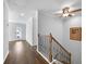 Hallway with hardwood floors, leading to a door with natural light, plus staircase with wrought iron railings at 625 Sienna Way, Summerville, SC 29486