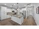 A modern kitchen with white cabinets and granite island, stainless steel refrigerator and hardwood floors at 625 Sienna Way, Summerville, SC 29486