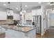 A modern kitchen with white cabinets and granite island, stainless steel refrigerator and hardwood floors at 625 Sienna Way, Summerville, SC 29486