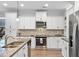 A modern kitchen features granite countertops, stainless steel appliances and white cabinetry at 625 Sienna Way, Summerville, SC 29486