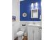 A stylish powder room with blue accent wall, white wainscoting, and modern fixtures at 625 Sienna Way, Summerville, SC 29486