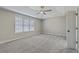 Bright main bedroom boasts tray ceilings, a ceiling fan, and plush gray carpeting at 659 Hamlet Cir, Goose Creek, SC 29445
