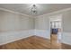 Bright dining room featuring hardwood floors, classic wainscoting, and modern lighting fixture at 659 Hamlet Cir, Goose Creek, SC 29445