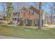 Two-story brick home featuring a spacious front yard, green shutters, and inviting porch at 659 Hamlet Cir, Goose Creek, SC 29445