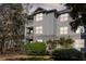 Three-story condominium with gray siding, balconies, manicured bushes, and a well-maintained lawn at 700 Daniel Ellis Dr # 5302, Charleston, SC 29412