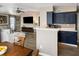 Open concept kitchen overlooking the living and dining rooms with bar top, wooden floor and blue cabinets at 700 Daniel Ellis Dr # 5302, Charleston, SC 29412