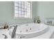 Spa-like bathroom featuring a large soaking tub, glass block window for privacy, and neutral colored walls at 726 Gypsy Ln, Mount Pleasant, SC 29464