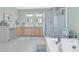Well-lit bathroom featuring double vanities, a glass shower, and a large soaking tub at 726 Gypsy Ln, Mount Pleasant, SC 29464