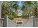 Stairway leading down to a spacious backyard with mature palm trees and a glimpse of the marsh at 7759 Edingsville Beach Rd, Edisto Island, SC 29438