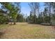 Lush backyard featuring a trampoline, with mature trees offering shade and privacy for outdoor enjoyment at 7759 Edingsville Beach Rd, Edisto Island, SC 29438