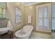 Elegant bathroom features a freestanding tub, marble floors, natural light, and modern fixtures at 7759 Edingsville Beach Rd, Edisto Island, SC 29438