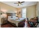 Comfortable bedroom featuring a ceiling fan, a large window with shutters, and hardwood floors at 7759 Edingsville Beach Rd, Edisto Island, SC 29438