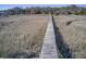Long wooden boardwalk through grassy marsh, connecting the property to waterfront features with a winding path at 7759 Edingsville Beach Rd, Edisto Island, SC 29438