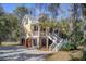 Beautiful two-story home featuring brick facade, double garage, and palm trees at 7759 Edingsville Beach Rd, Edisto Island, SC 29438
