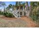 Charming home with palm trees and double staircases leading to the front porch at 7759 Edingsville Beach Rd, Edisto Island, SC 29438
