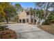 Attractive stilted home featuring a garage, palm trees and double staircases leading to the front porch at 7759 Edingsville Beach Rd, Edisto Island, SC 29438
