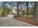 Inviting home exterior with a side driveway, lush greenery, and charming architectural details at 7759 Edingsville Beach Rd, Edisto Island, SC 29438