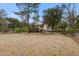 Quaint home with a tan exterior, complemented by a spacious yard and mature trees for added privacy at 7759 Edingsville Beach Rd, Edisto Island, SC 29438