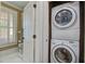 Convenient laundry area with stacked washer and dryer and bright light from the window at 7759 Edingsville Beach Rd, Edisto Island, SC 29438