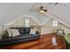 Comfortable loft area with a cozy couch, hardwood floors, and ceiling fans at 7759 Edingsville Beach Rd, Edisto Island, SC 29438