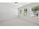 Bright, empty bedroom featuring carpet, neutral walls, and multiple windows with views of neighboring houses at 808 Alma Square Dr, Moncks Corner, SC 29461