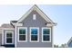 Close-up of a well-built home exterior with white trim windows and gray vertical siding at 808 Alma Square Dr, Moncks Corner, SC 29461