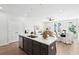 Bright and airy kitchen featuring a center island with gray cabinets and an open floor plan leading to the living and dining areas at 808 Alma Square Dr, Moncks Corner, SC 29461