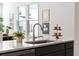 Close-up of the kitchen island with quartz countertops, stainless steel sink, and views of the dining area at 808 Alma Square Dr, Moncks Corner, SC 29461