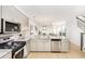 Modern kitchen with stainless steel appliances, white cabinets, and an open layout connecting to the dining and living areas at 810 Alma Square Dr, Moncks Corner, SC 29461