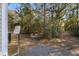 View of the wooded backyard of the home with mature trees and a gravel and stone pathway at 8255 Chisolm Plantation Rd, Edisto Island, SC 29438