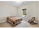 A carpeted bedroom with a bed, rocker, and view to the outdoors at 8255 Chisolm Plantation Rd, Edisto Island, SC 29438