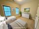 Staged bedroom with two twin beds, carpet floors, white walls, and lots of light at 8255 Chisolm Plantation Rd, Edisto Island, SC 29438