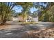 Well-maintained property with a spacious driveway, detached garage, and lush trees at 8255 Chisolm Plantation Rd, Edisto Island, SC 29438