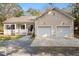 Charming single-story home with a two-car garage, welcoming front porch, and neutral siding at 8255 Chisolm Plantation Rd, Edisto Island, SC 29438