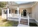 Charming front porch with a black door, brick steps, and a white railing around the perimeter at 8255 Chisolm Plantation Rd, Edisto Island, SC 29438