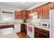 Bright kitchen features wood cabinets, granite countertops, white appliances, and hardwood floors at 8255 Chisolm Plantation Rd, Edisto Island, SC 29438