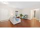 Bright living room with hardwood floors, a white couch, blue chair, and a view of the front yard at 8255 Chisolm Plantation Rd, Edisto Island, SC 29438