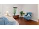 Bright living room with hardwood floors, a white couch, blue chair, and a view of the front yard at 8255 Chisolm Plantation Rd, Edisto Island, SC 29438