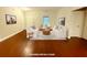Bright and neutral living room featuring two sofas, wooden floors, artwork and area rug at 8255 Chisolm Plantation Rd, Edisto Island, SC 29438