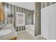Bathroom with dual sinks, a built-in tub, striped wallpaper and a tiled floor at 8615 Arthur Hills Cir, North Charleston, SC 29420