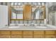 Bathroom featuring dual sinks, wooden cabinets, and striped wallpaper at 8615 Arthur Hills Cir, North Charleston, SC 29420